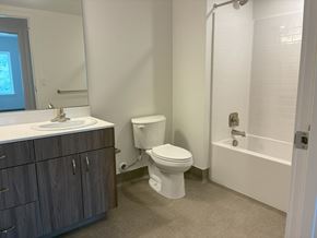 Mcminnvile apartment for rent - A white toilet sits in a bathroom next to a sink and bathtub.