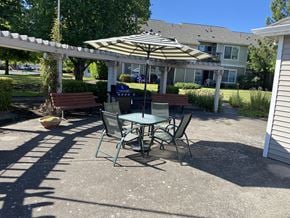 Mcminnville apartment for rent - A patio with a table and chairs under an umbrella.