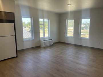 Mcminnvile apartment for rent - A kitchen with a white refrigerator and wooden floors.