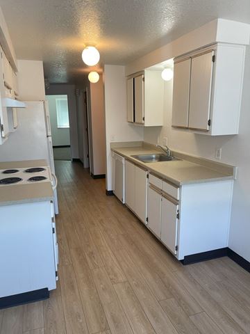 Newberg apartment for rent - A kitchen with white appliances and wooden floors.