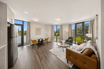 Kitchener apartment for rent - A modern living room with a brown sofa and a dining table with chairs.