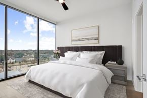 Dallas apartment for rent - a bedroom with a king sized bed and a large window