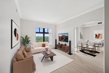 Denver apartment for rent - A living room with a brown couch, a coffee table, and a painting on the wall.