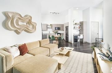 Davie apartment for rent - A living room with a tan couch and a large sculpture on the wall.
