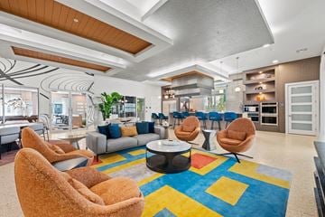 Melbourne apartment for rent - A living room with a blue rug and two orange chairs.