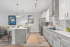 Melbourne apartment for rent - A kitchen with a table and chairs and a framed picture on the wall.