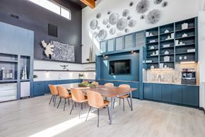 Broomfield apartment for rent - a kitchen with blue cabinets and a wooden table and chairs at Arista Uptown Apartments, Broomfield, 80021