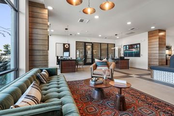 Phoenix apartment for rent - A living room with a green sofa and a patterned rug.