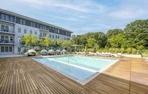 Hingham apartment for rent - a swimming pool with a wooden deck and a building in the background