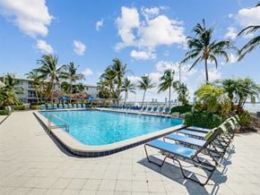 Lake Park apartment for rent - a resort style pool with chaise lounge chairs and palm trees
