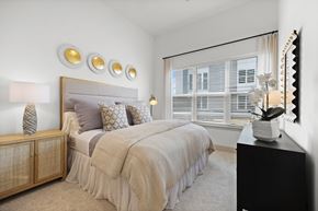 Hyannis apartment for rent - A bedroom with a large bed and a mirror on the wall.