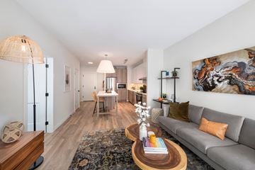 Conshohocken apartment for rent - A living room with a grey couch, a coffee table, and a large painting on the wall.