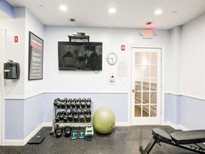 Valley Stream apartment for rent - a gym with a television and weights on the floor