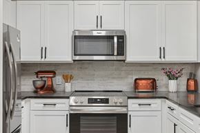 Atlanta apartment for rent - A modern kitchen with white cabinets and stainless steel appliances.