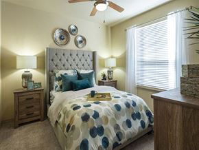 Houston apartment for rent - a bedroom with a bed and a ceiling fan at Retreat at Shadow Creek Ranch Apartments, Texas
