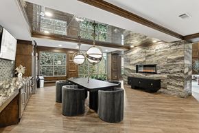 Dallas apartment for rent - A modern kitchen with a stone fireplace and a dining table with chairs.