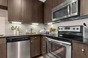 Dallas apartment for rent - A modern kitchen with dark wood cabinets and stainless steel appliances.