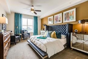 Dallas apartment for rent - A bedroom with a large bed and a ceiling fan.
