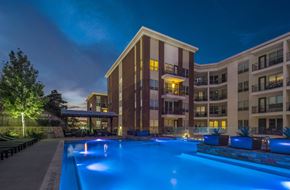 Dallas apartment for rent - A large building with a pool in front of it.