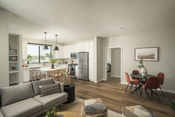 Tempe apartment for rent - A modern living room with a grey sofa and a dining table with chairs.