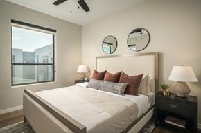 Tempe apartment for rent - A bedroom with a large bed, two lamps, and a ceiling fan.