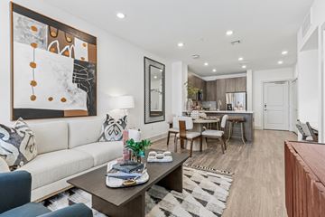Hyannis apartment for rent - A modern living room with a large painting on the wall and a coffee table in the center.