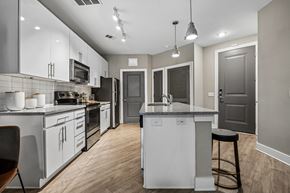 Charlotte apartment for rent - A modern kitchen with a large island with two bar stools.