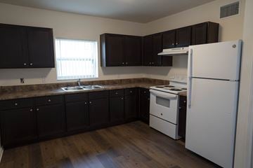 Jacksonville apartment for rent - A kitchen with black cabinets and a white refrigerator.