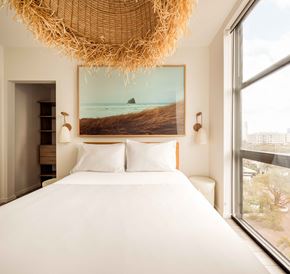 Fort Lauderdale apartment for rent - A bedroom with a large bed and a large painting of a beach scene on the wall.