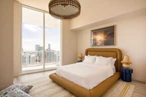 Miami apartment for rent - A bedroom with a large bed and a view of the city.