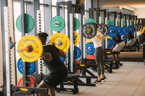 Miami apartment for rent - a group of people lifting weights in a gym
