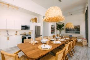 Miami apartment for rent - a dining room with a wooden table and chairs and a kitchen
