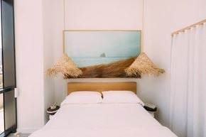 Miami apartment for rent - a bedroom with a white bed and a picture of the ocean