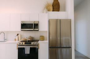 Miami apartment for rent - a kitchen with stainless steel appliances and white cabinets