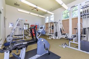 Dallas apartment for rent - a gym with cardio equipment and weights in a building with windows