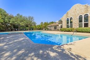 Dallas apartment for rent - A large swimming pool in front of a house.