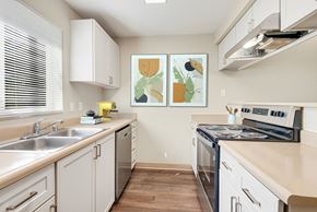 Everett apartment for rent - a modern kitchen with white cabinets and stainless steel appliances at Sage Apartments, Washington