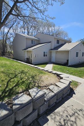 Pocatello apartment for rent - A house with a grey roof and a stone wall in front.