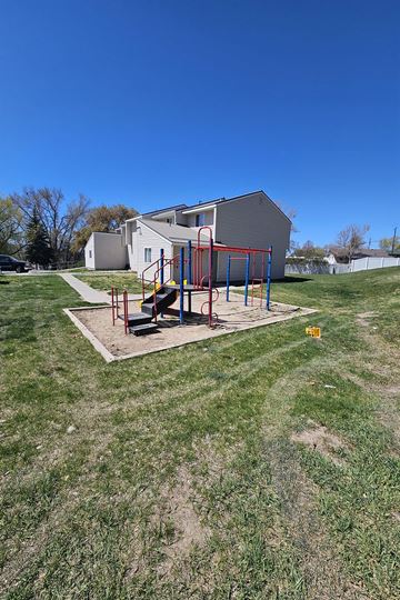 Pocatello apartment for rent - A playground with a swing set in the middle of a grassy area.
