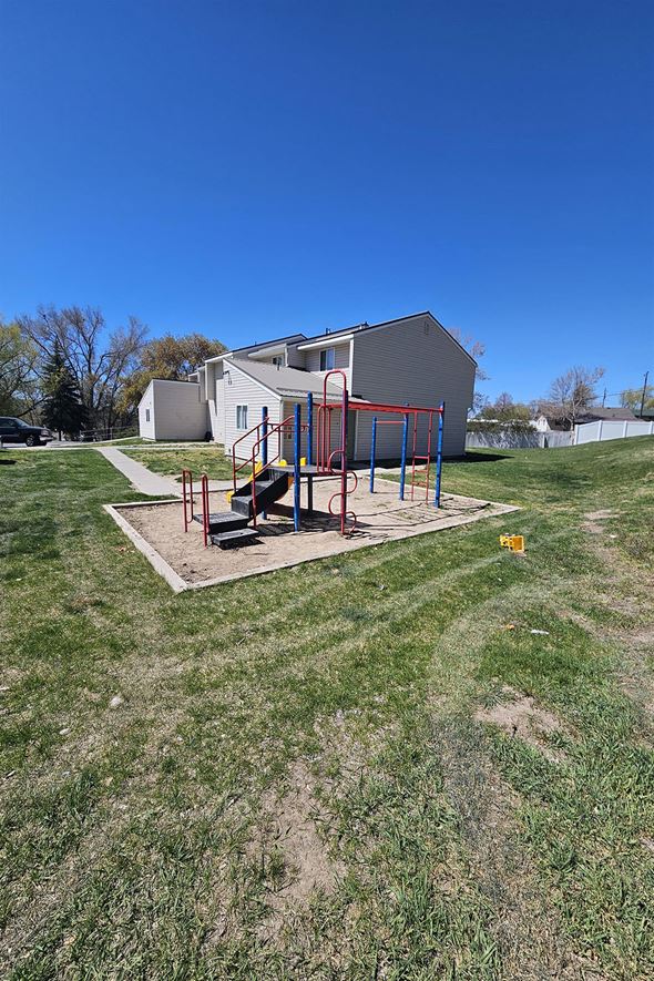 Pocatello apartment for rent - A playground with a swing set in the middle of a grassy area.