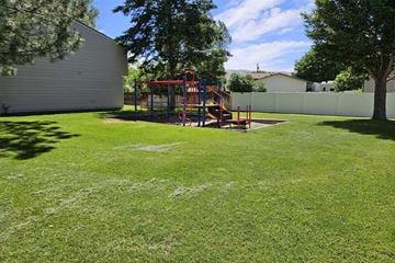 Pocatello apartment for rent - A playground with a red swing set in a grassy area.