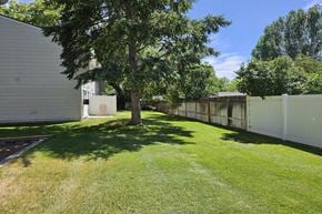 Pocatello apartment for rent - A tree in a yard with a white fence.