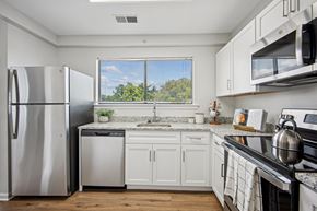 Bethesda apartment for rent - A kitchen with white cabinets and a stainless steel refrigerator at Elme Bethesda, Bethesda, 20814