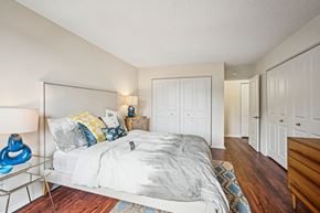 Alexandria apartment for rent - A bedroom with a bed, nightstand, and a lamp at Riverside Apartments, Alexandria, Virginia
