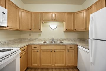 Cudahy apartment for rent - A kitchen with wooden cabinets and a white refrigerator.