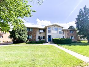 Madison apartment for rent - the view of an apartment building with a lawn and sidewalk in front of it