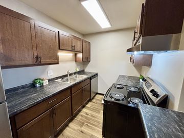 Madison apartment for rent - A kitchen with dark wood cabinets and a black counter top.