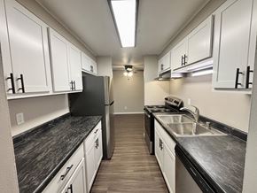 Madison apartment for rent - A kitchen with black countertops and white cabinets.