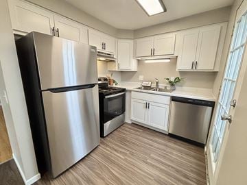 Madison townhouse for rent - A kitchen with a stainless steel refrigerator and wooden flooring.