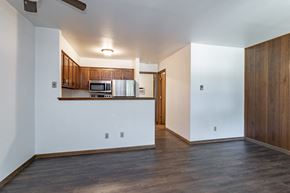 Stevens Point apartment for rent - an empty living room with wood floors and white walls and a kitchen